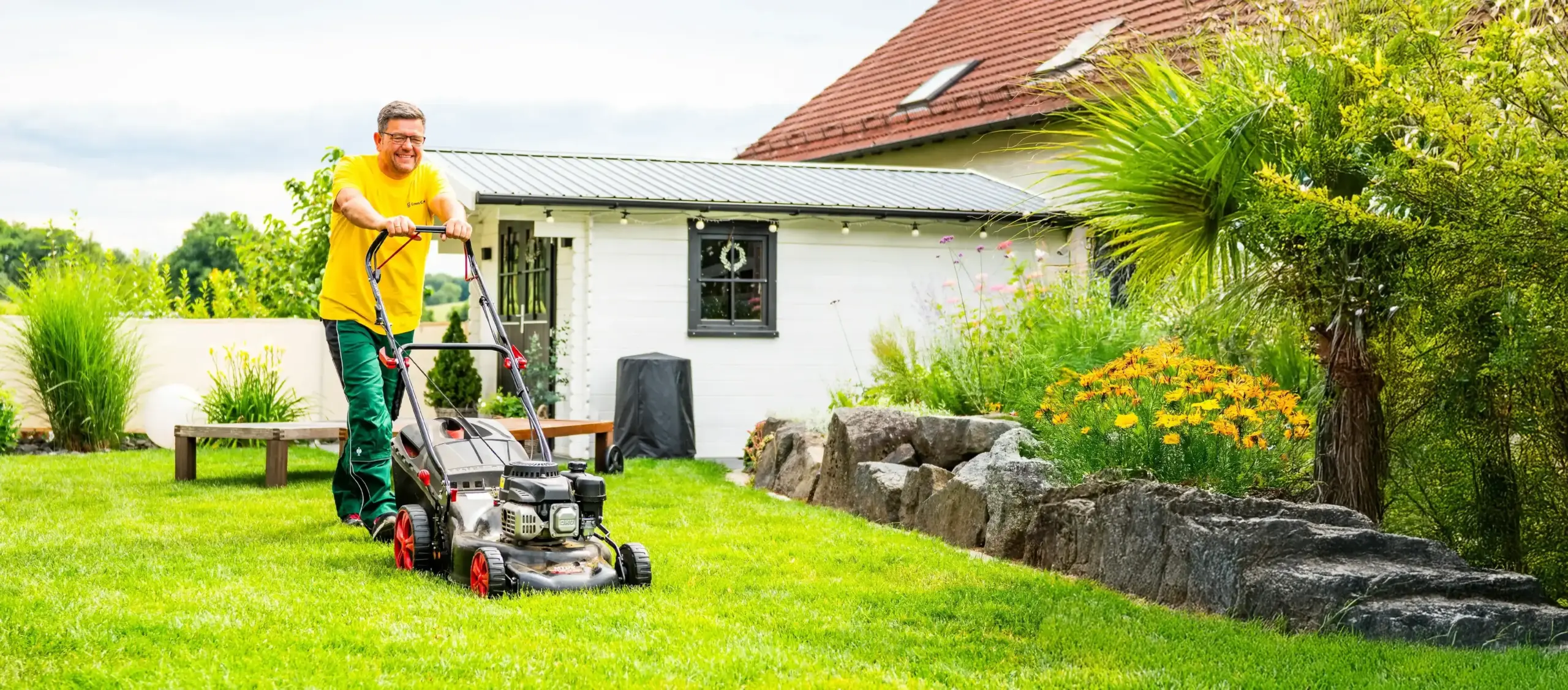 Green Crew Mitarbeiter beim Mähen im Garten