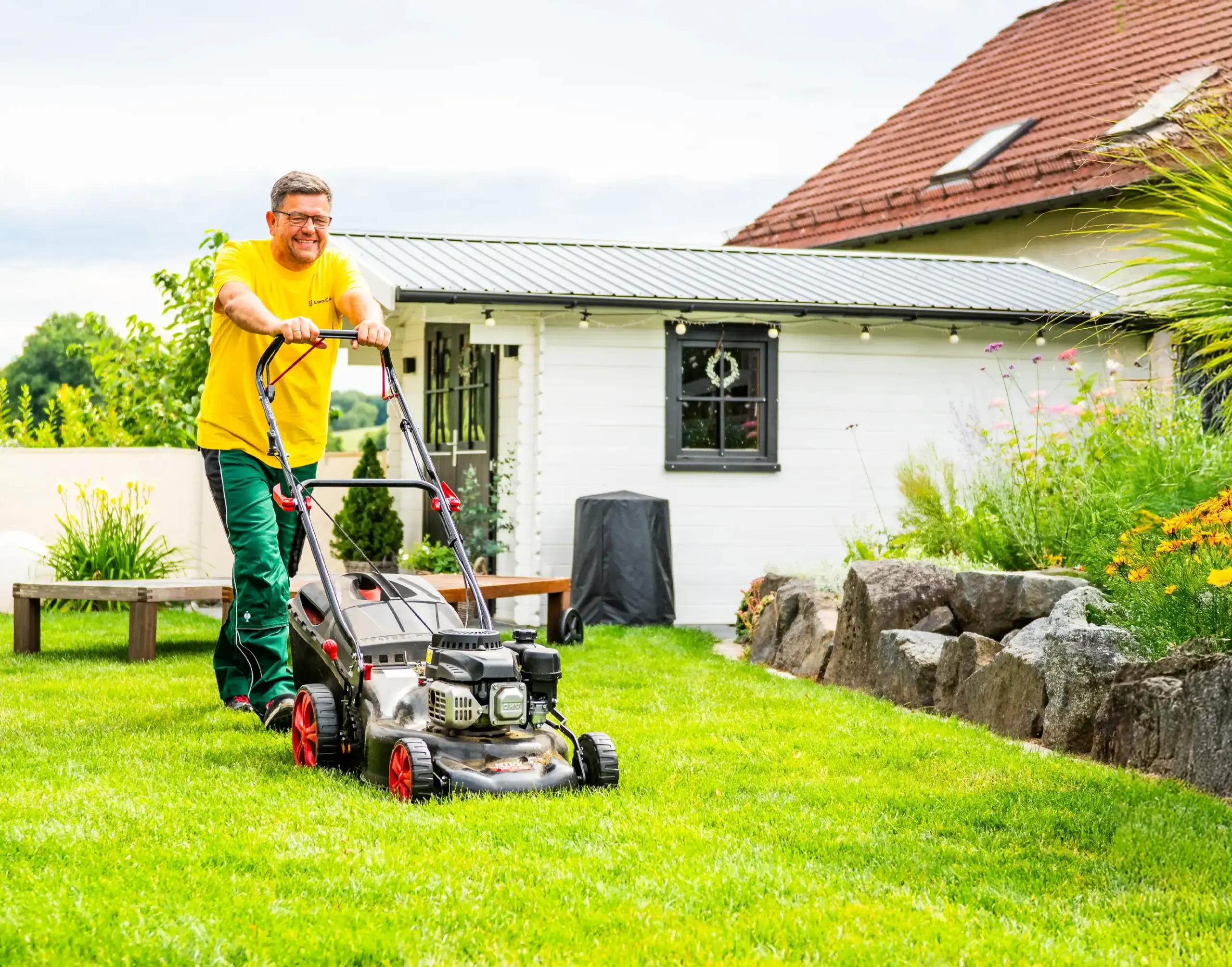 Green Crew Mitarbeiter beim Mähen im Garten